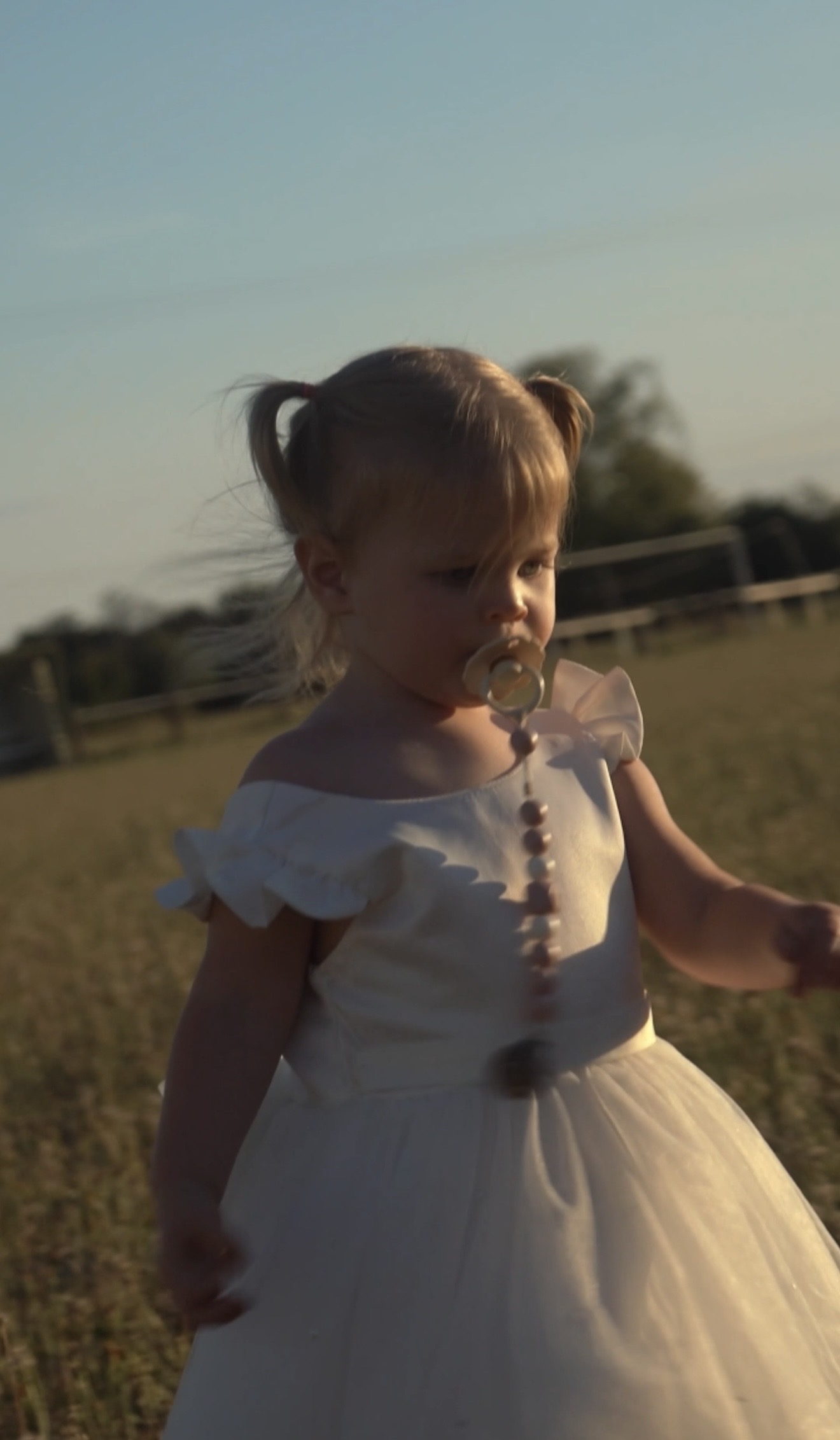 Little girl in a white dress in warm evening light